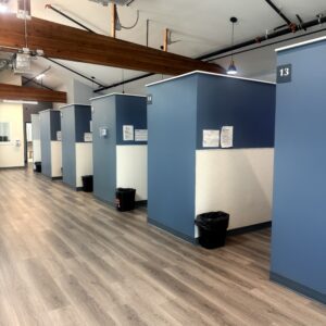 Modern community health clinic booths with blue walls and wooden accents.
