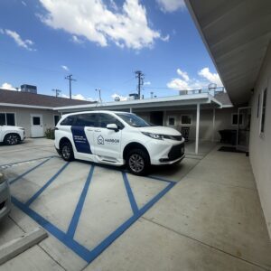 Harbor Care Foundation vehicle parked outside building under blue sky.