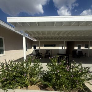 Accessible outdoor seating area at Harbor Care Foundation building with benches and greenery.